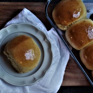 cooked honey butter yeast rolls in a baking dish