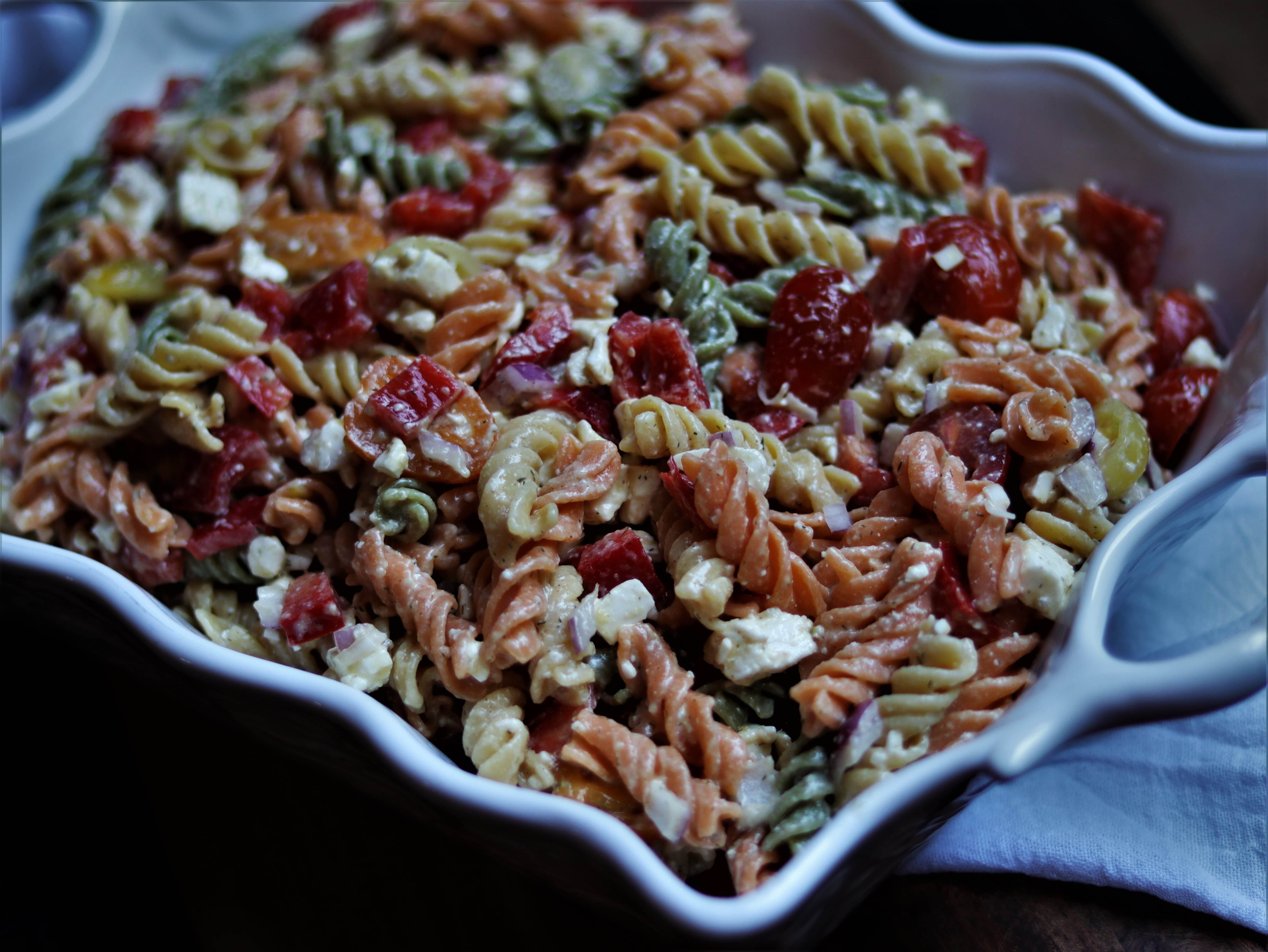 veggie pasta salad with honey dijon salad dressing in a serving dish