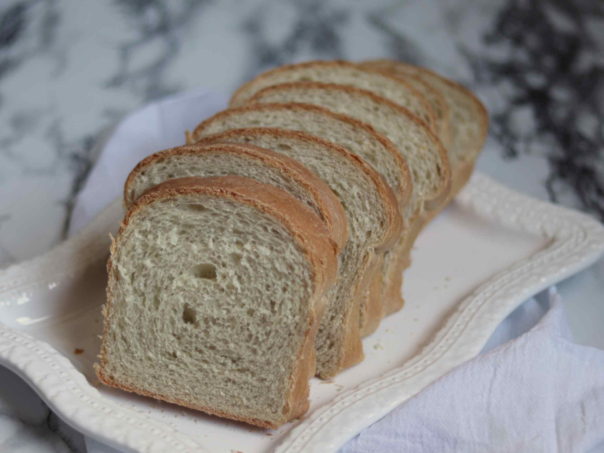 homemade sandwich bread slices on a white serving tray