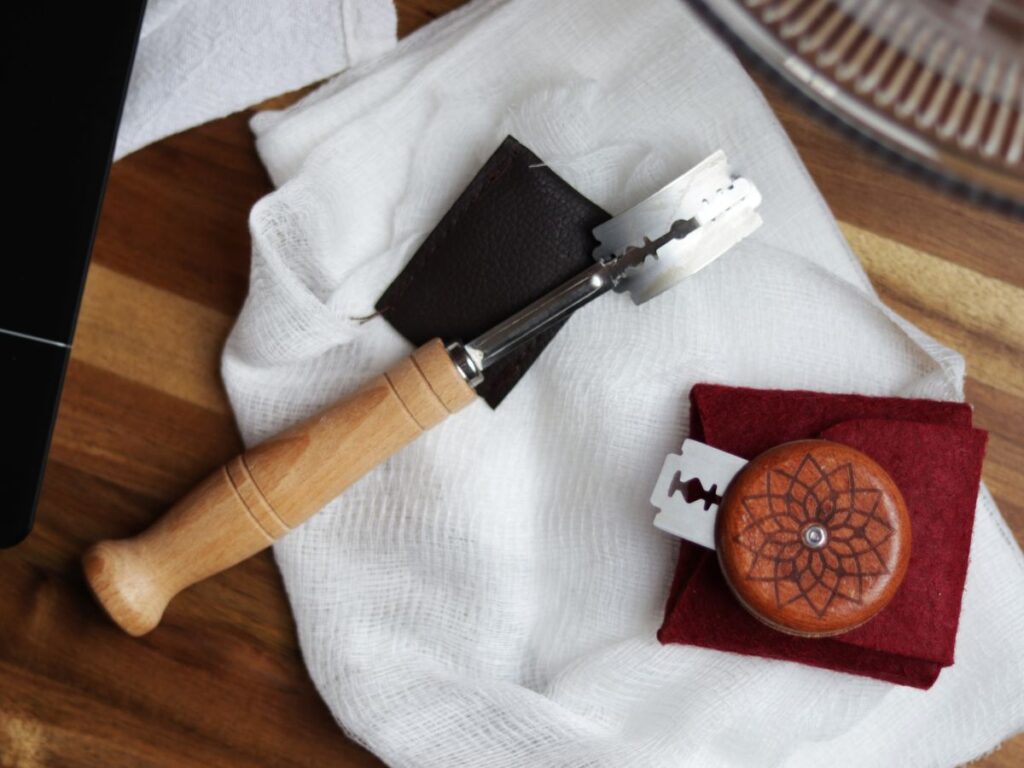 sourdough scoring tools sitting on top of a cheese cloth on a wooden cutting board