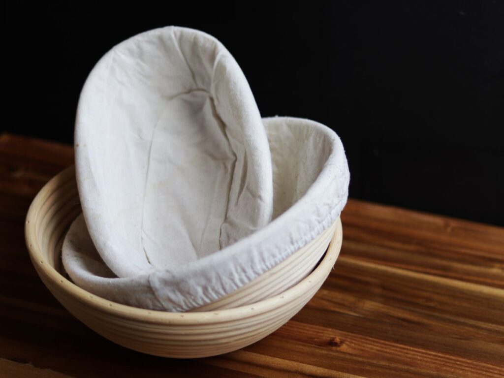 three banneton sourdough bread proofing baskets on a wooden cutting board