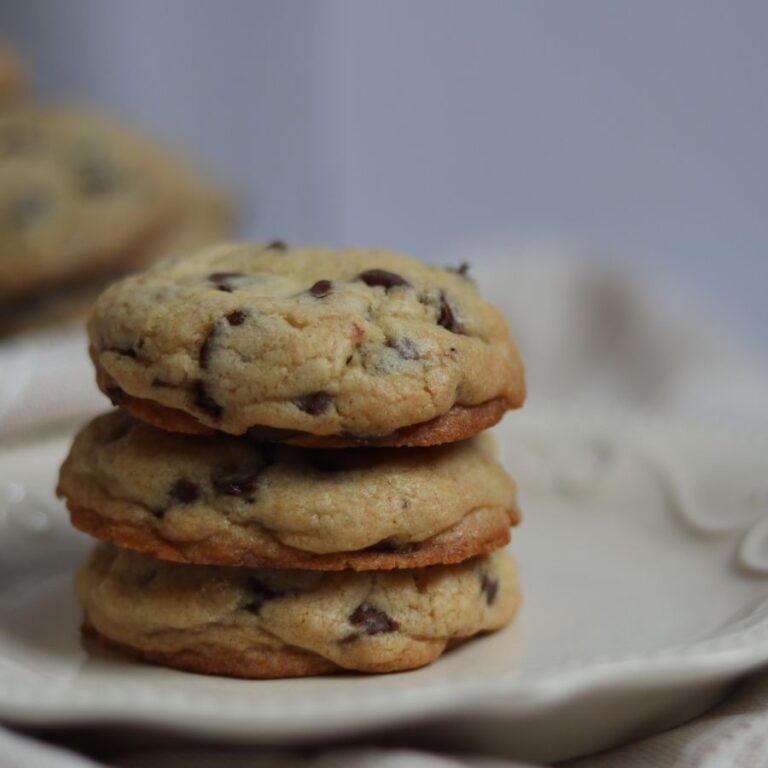 up close image of a stack of three chocolate chip cookies on a small plate